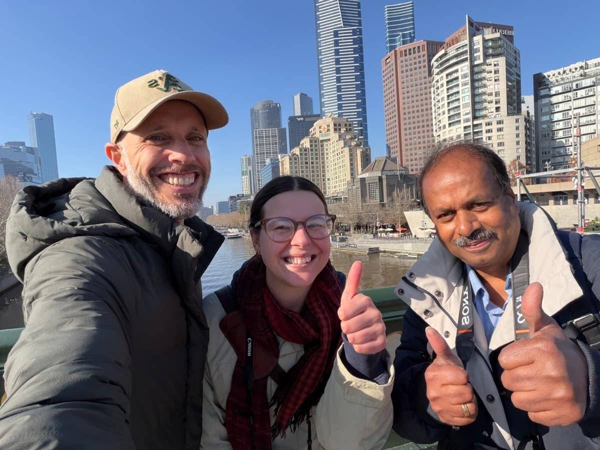 Elan and Cosette with Daniel Bilsborough on a bridge over the Yarra River, Melbourne CBD skyline behind, during a photography course