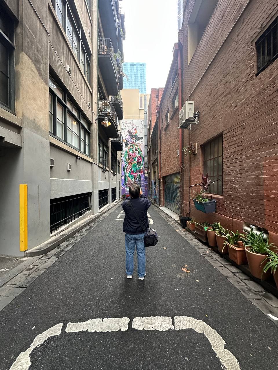 Joseph photographing street art in a Melbourne CBD laneway during a photography course