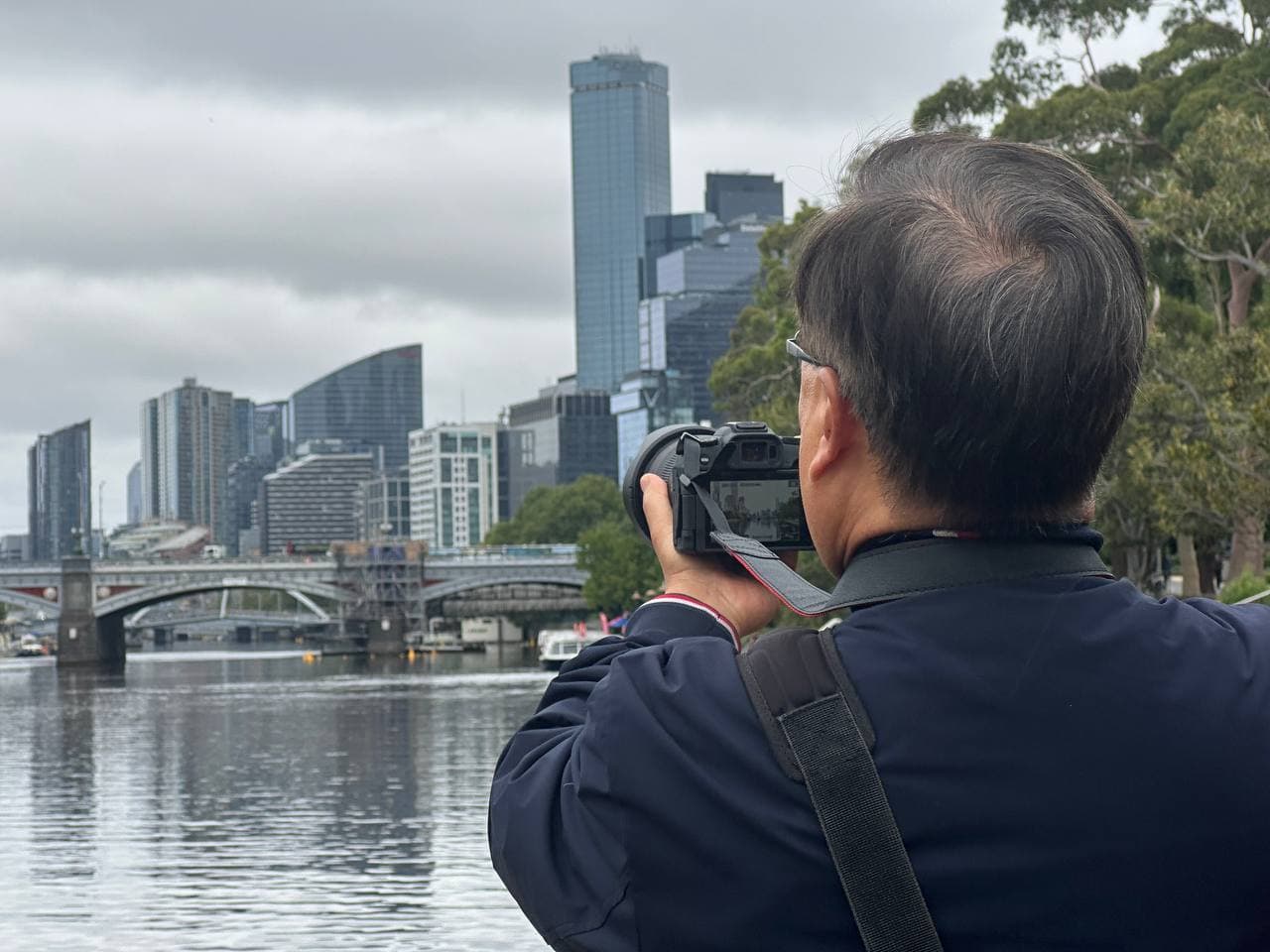 Joseph shooting the Melbourne skyline from the Yarra River with his Canon R8 during a photography course