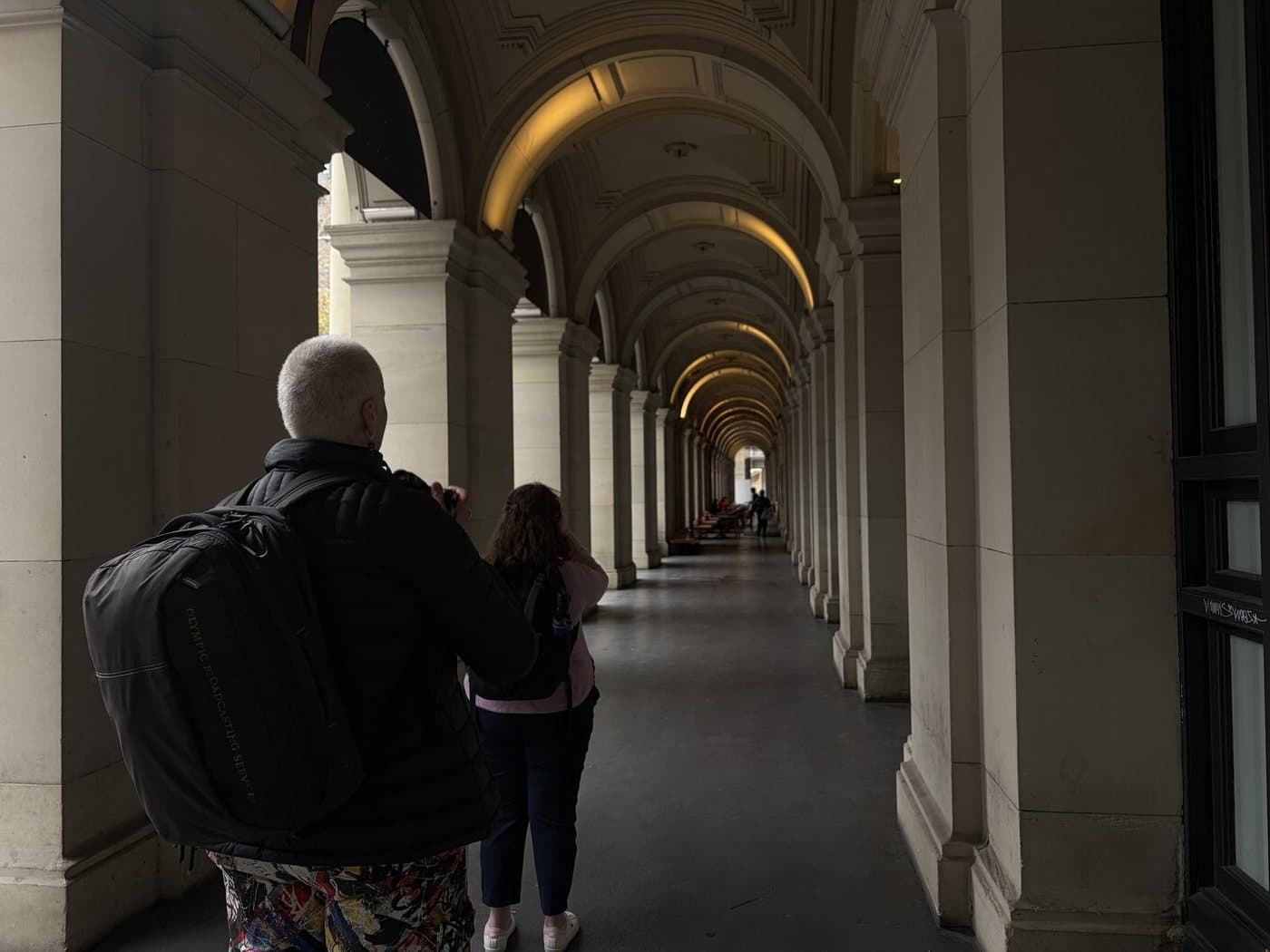 Two students photographing the arches of a Melbourne CBD colonnade during a photography course