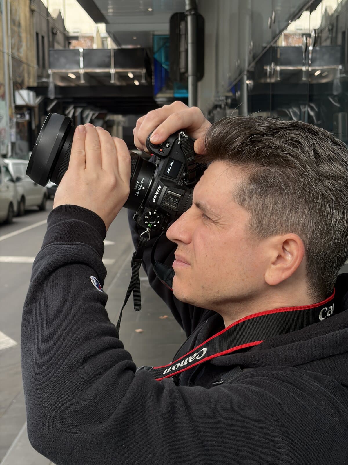 Michael shooting his Nikon Z6 II with the NIKKOR Z 28-400mm lens in a Melbourne laneway during a manual mode photography course