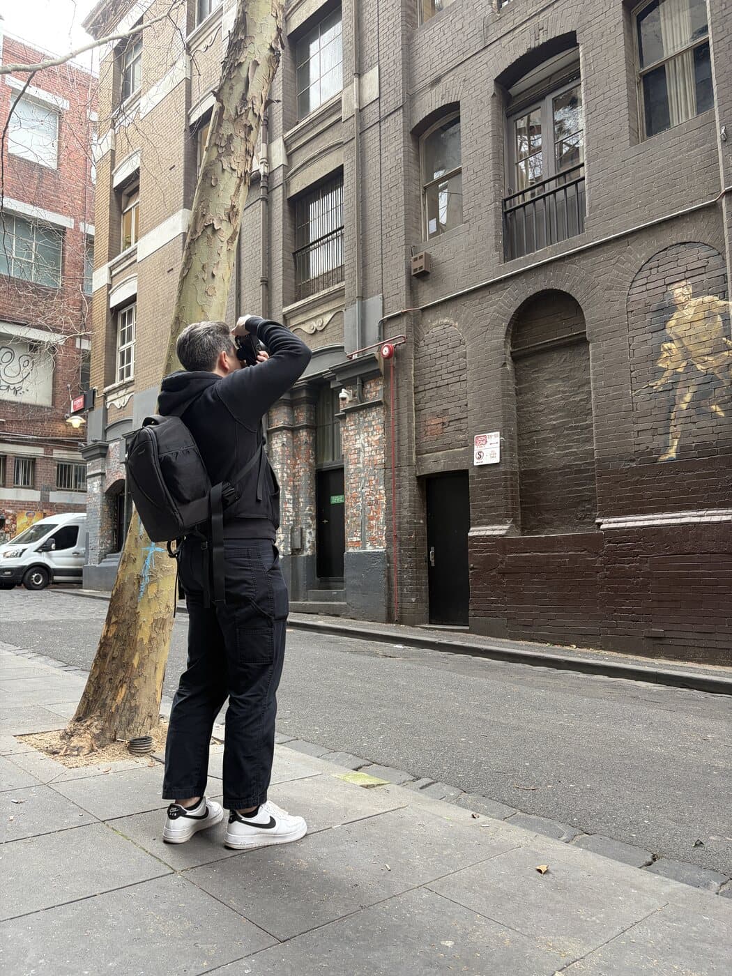 Michael shooting upwards at heritage brickwork with a Nikon Z6 II and 28-400mm lens on a Melbourne CBD street during a photography course