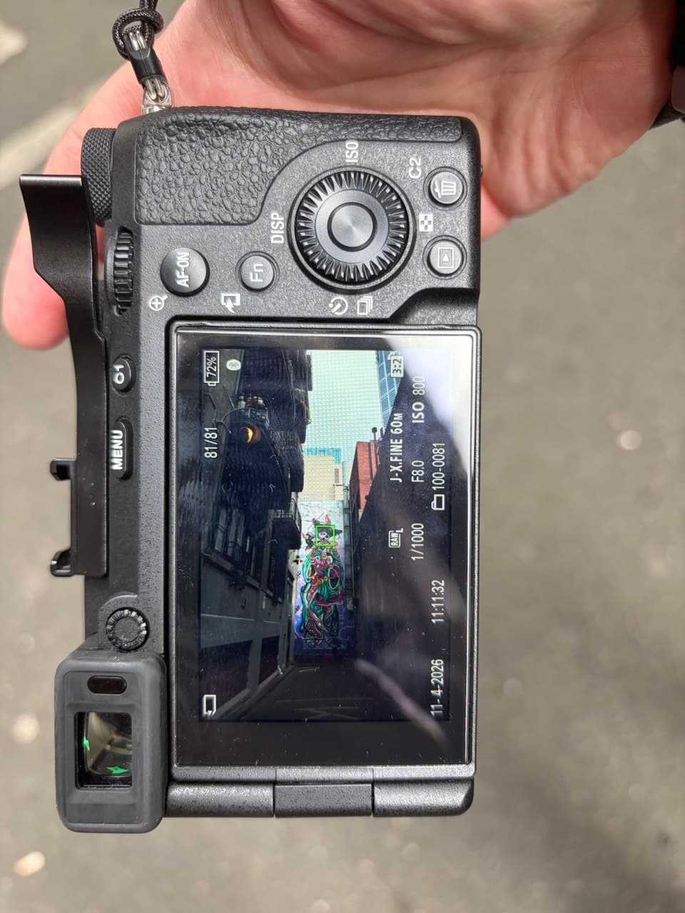 Rear LCD of Ron's Sony A7CR showing a Melbourne laneway street art composition with settings visible: 1/1000s, f/3.0, ISO 800