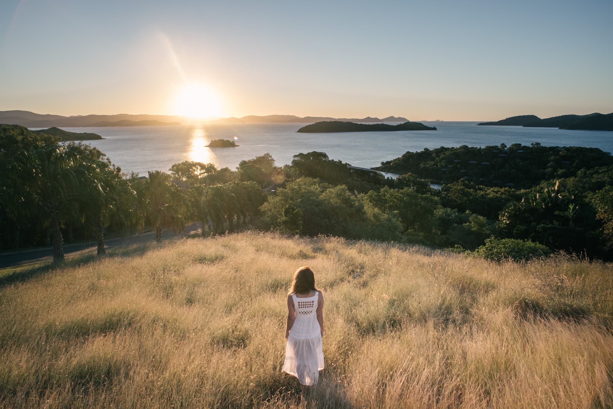 Portrait of a woman in a white dress at sunset overlooking the ocean